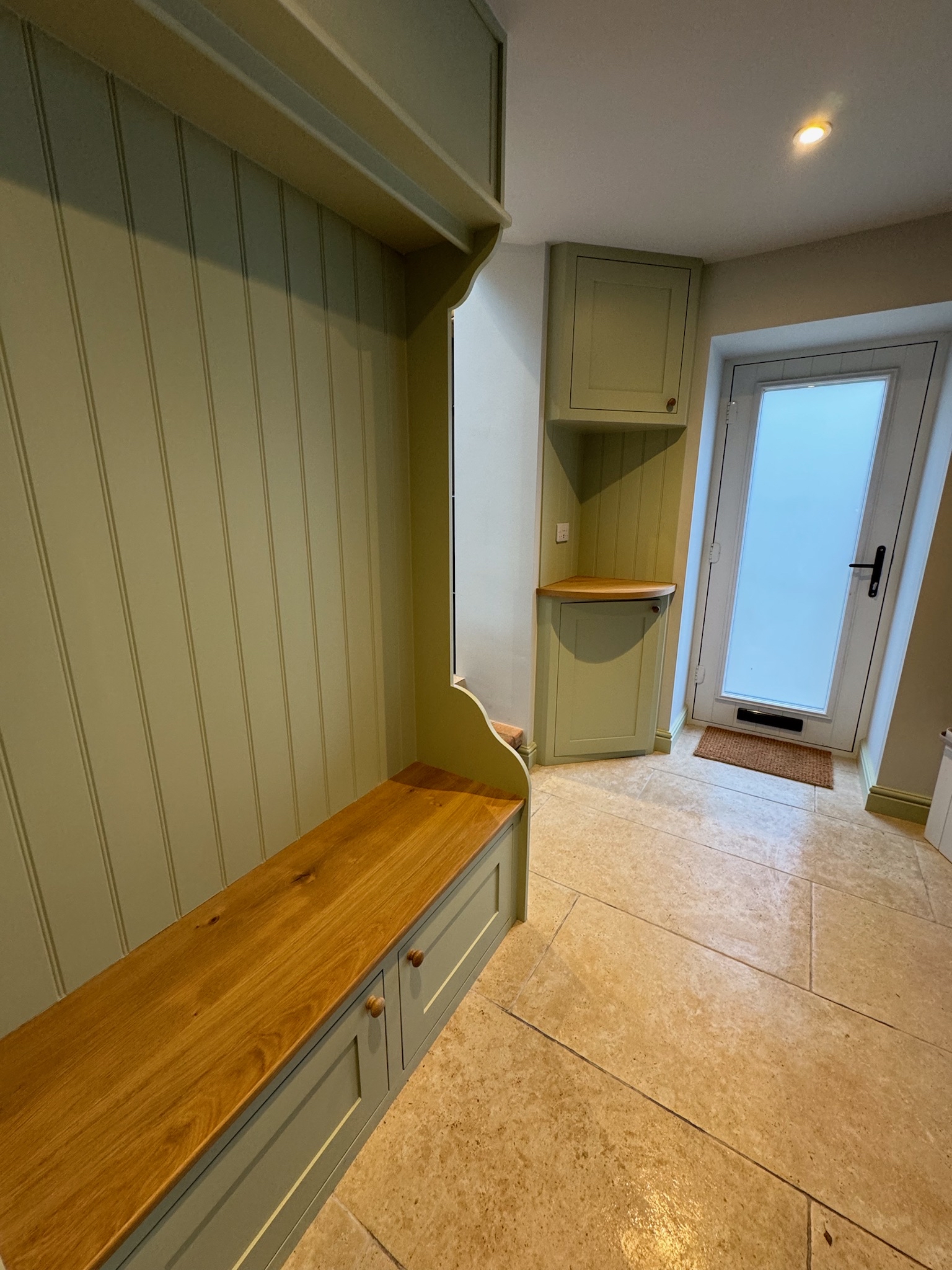 Green and timber unit and seatting area for shoes and coat. Porcelain floor.