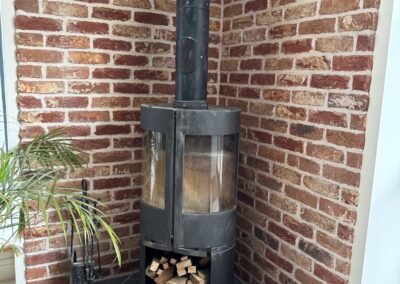Log burner with slate hearth and brick slips surround